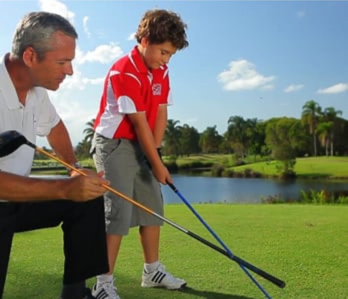 Grant Garrison coaching a young golfer on the course